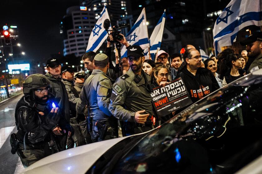 TEL AVIV, ISRAEL -- MARCH 2, 2024: Police officers push back protesters blocking the road and try to clear congested traffic on main roads during an anti-government protest in Tel Aviv, Israel, Saturday, March 2, 2024. Protests against the Netanyahu government took place across Israel, calling for early elections, and for the immediate return of Israeli hostages held in Gaza. (MARCUS YAM / LOS ANGELES TIMES)