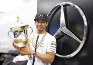 Mercedes Formula One driver Lewis Hamilton of Britain celebrates winning the Bahrain Grand Prix with the trophy in Sakhir April 19, 2015. Action Images via Reuters / Hoch Zwei