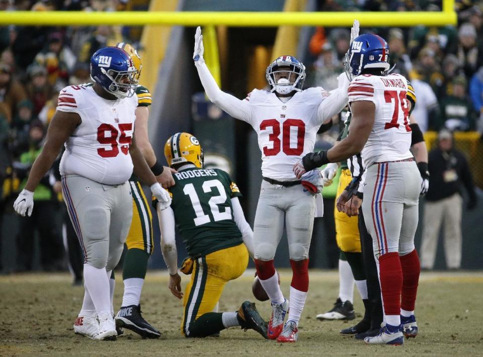 New York Giants cornerback Coty Sensabaugh (30) celebrates after a quarterback sack as Green Bay Packers quarterback Aaron Rodgers (12) gets up during the first half of an NFC wild-card NFL football game against the Green Bay Packers, Sunday, Jan. 8, 2017, in Green Bay, Wis. (AP Photo/Mike Roemer)