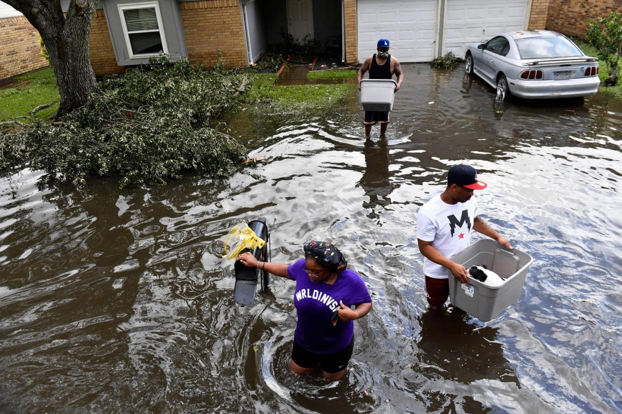 <span class="caption">People wade through high water to evacuate a flooded home in LaPlace, La., after Hurricane Ida struck.</span> <span class="attribution"><a class="link " href="https://www.gettyimages.com/detail/news-photo/darrin-heisser-evacuates-from-his-flooded-home-with-his-dog-news-photo/1234968464" rel="nofollow noopener" target="_blank" data-ylk="slk:Patrick T. Fallon/AFP via Getty Images;elm:context_link;itc:0;sec:content-canvas">Patrick T. Fallon/AFP via Getty Images</a></span>