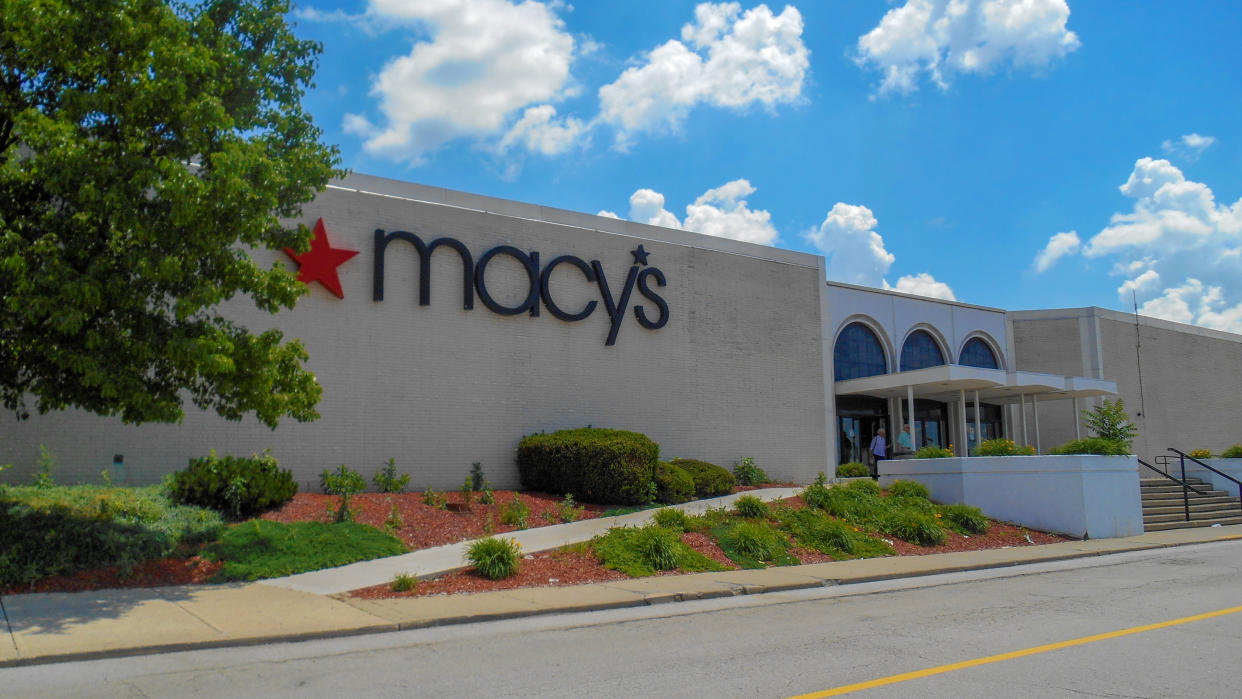 Fairview Heights, IL—June 1, 2018; landscaping near entrance to retailer with corporate sign with star logo hanging on outside wall. Cincinnati based Macy’s department stores operates over 660 locations in the United States and is a common anchor tenant at many suburban malls.