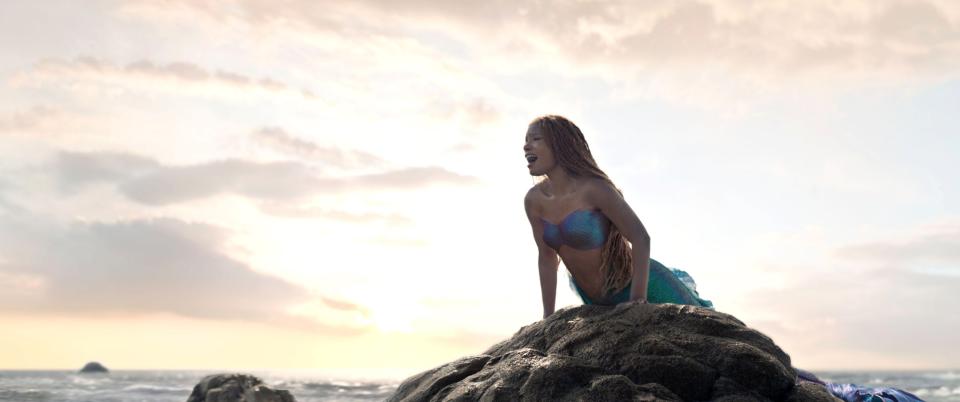Halle Bailey as Ariel on a rock formation