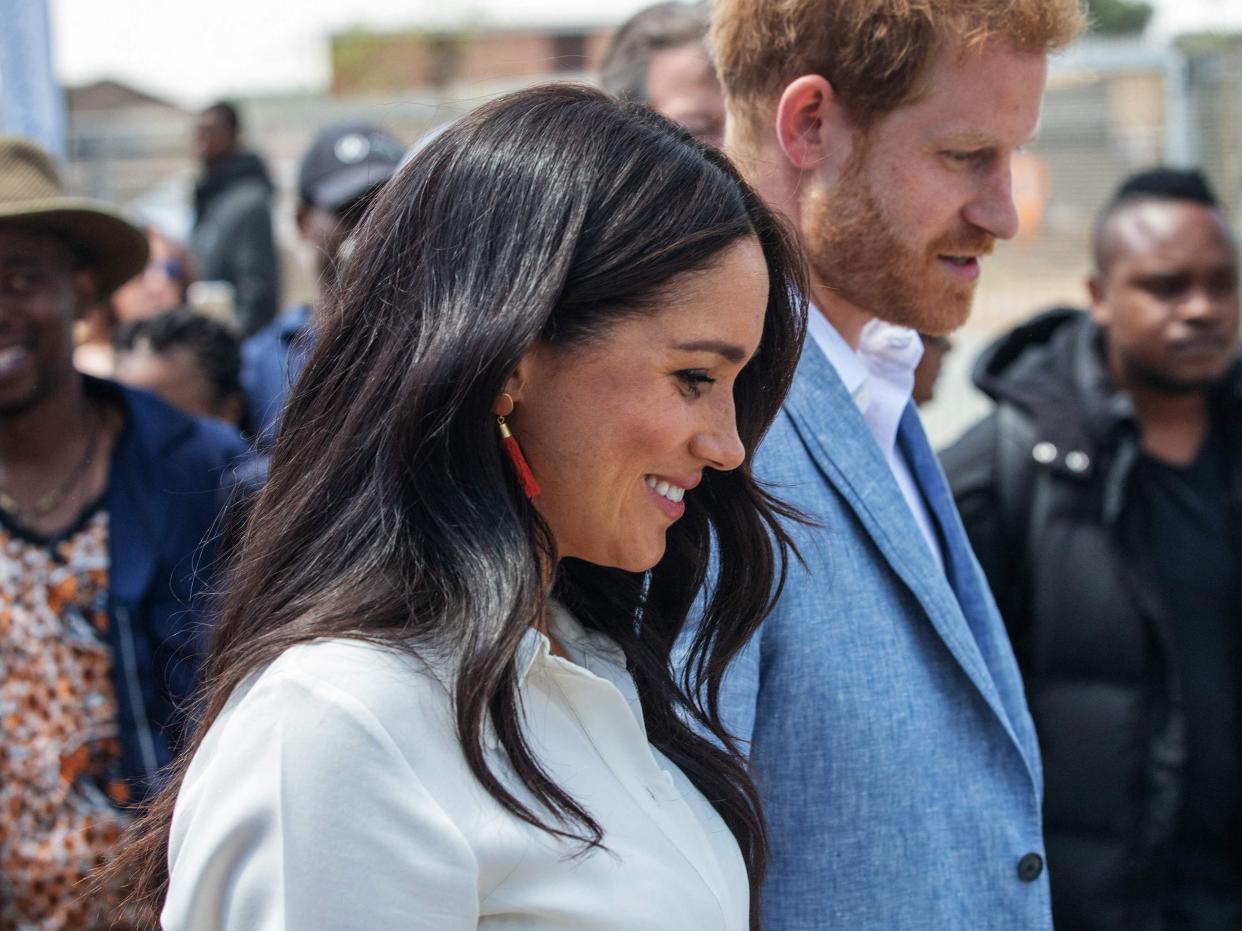 Prince Harry and Meghan leave the Youth Employment Services Hub in Tembisa township, Johannesburg (AFP via Getty Images)