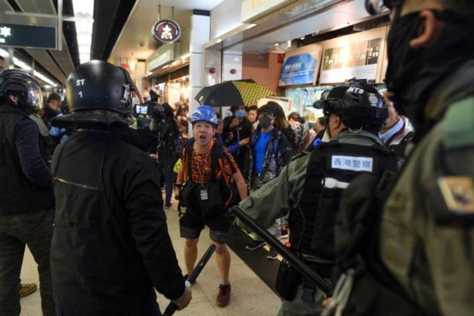 A photojournalist (C) argues with police during a protest at the New Town Plaza shopping mall in Shatin in Hong Kong during 2019 protests (AFP via Getty Images)