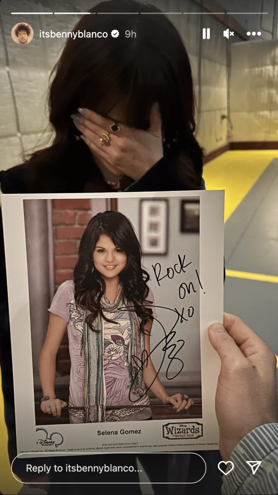 Selena Gomez hides her face behind a photo of her younger self. (@itsbennyblanco / Instagram)