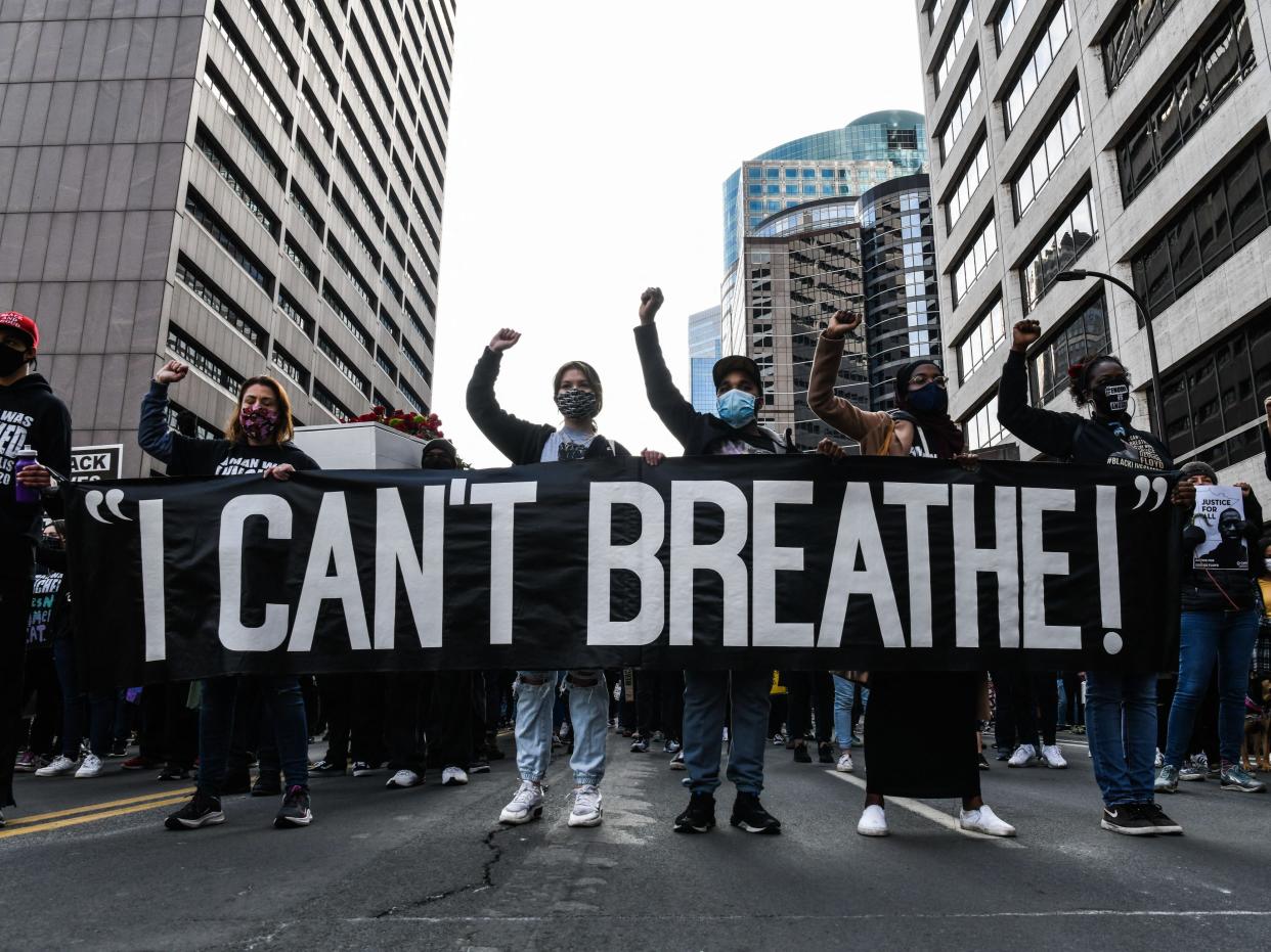 En esta foto de archivo, los manifestantes sostienen una pancarta durante la Marcha silenciosa por la justicia, No puedo respirar, frente al Centro de Gobierno del Condado de Hennepin, el 7 de marzo de 2021. ((AFP via Getty Images))