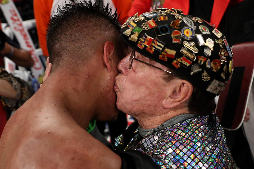 Rafael Garcia (R), shown kissing fighter Jessie Vargas after Vargas won the world title, died Tuesday at 88. (Getty Images)