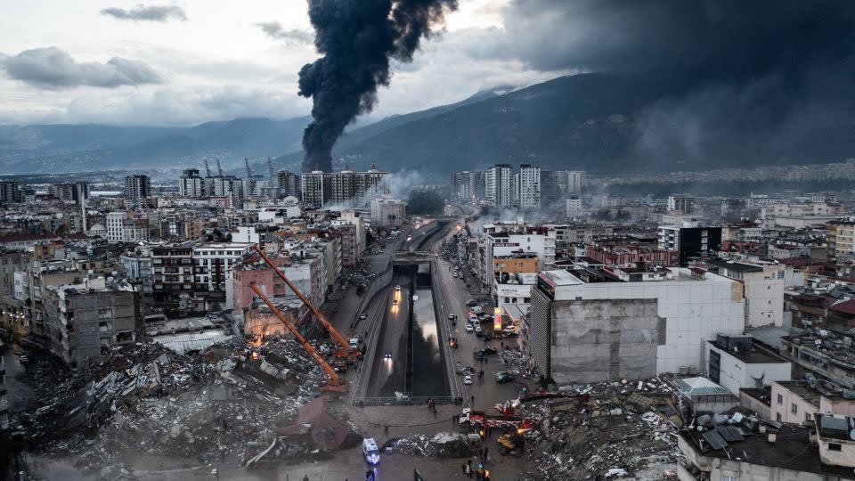 Smoke billows from the Iskenderun Port as rescue workers work at the scene of a collapsed building on February 7, 2023 in Iskenderun, Turkey. - Burak Kara/Getty Images