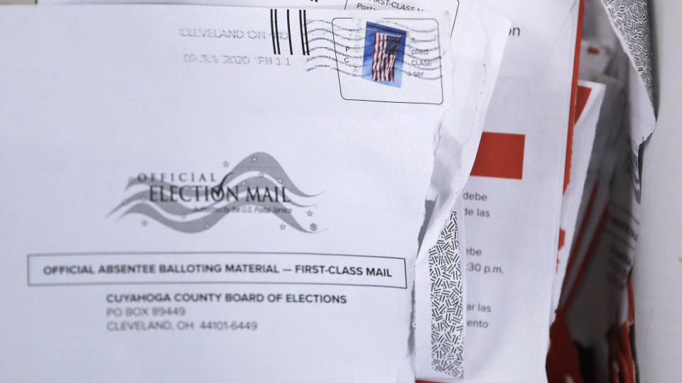 Applications for voter ballots are seen at the Cuyahoga County Board of Elections Tuesday, July 14, 2020, in Cleveland. As more states embrace mail-in balloting, an often overlooked detail has emerged as a partisan dividing line: postage. Questions over whether postage will be required for absentee ballot applications and ballots themselves, who pays for it and what happen to envelopes without stamps are the subject of lawsuits and Statehouse political brawls. (AP Photo/Tony Dejak)