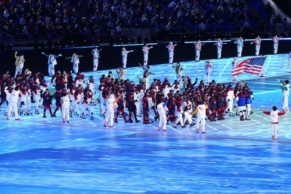 CORRECTS TO BRITTANY BOWE AND NOT ELANA MEYERS TAYLOR AS ORIGINALLY SENT - Brittany Bowe and John Shuster, of the United States, carry their country's flag during the opening ceremony of the 2022 Winter Olympics, Friday, Feb. 4, 2022, in Beijing. (AP Photo/Bernat Armangue)