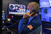 In this photo provided by the New York Stock Exchange, the presidential inaugural plays on a screen as trader Timothy Nick works in a booth on the trading floor, Wednesday, Jan. 20, 2021. U.S. stocks are rallying to records Wednesday on encouraging earnings reports and continued optimism that new leadership in Washington will mean more support for the struggling economy. (Colin Ziemer/New York Stock Exchange via AP)