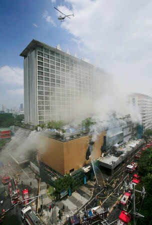 A helicopter flies over the building to rescue hotel guests and workers who were trapped after a fire engulfed the Manila Pavilon hotel in Metro Manila, Philippines March 18, 2018. REUTERS/Romeo Ranoco