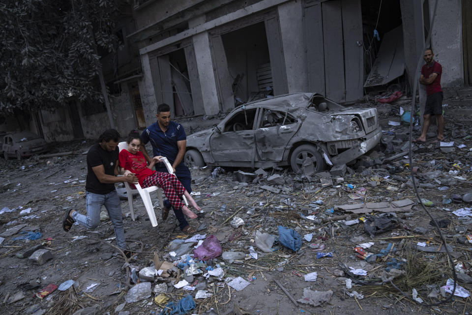 Palestinians walk amid the rubble following Israeli airstrikes that razed swaths of a neighborhood in Gaza City, Tuesday, Oct. 10, 2023. The militant Hamas rulers of the Gaza Strip carried out an unprecedented attack on Israel Saturday, killing over 900 people and taking captives. Israel launched heavy retaliatory airstrikes on the enclave, killing hundreds of Palestinians. (AP Photo/Fatima Shbair)