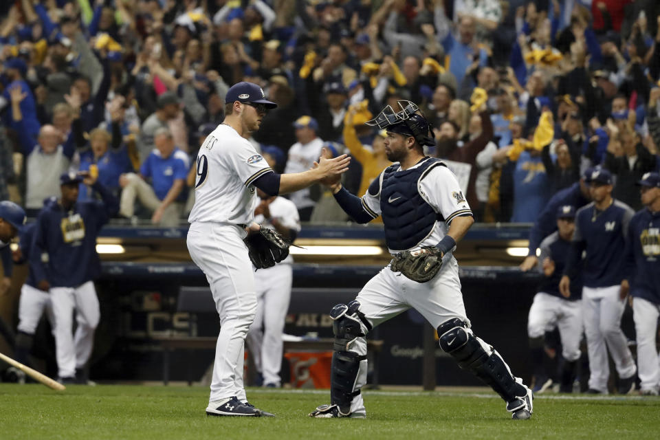 Milwaukee Brewers relief pitcher Corbin Burnes (39) and catcher Manny Pina (9) celebrate after Game 6 of the National League Championship Series baseball game against the Los Angeles Dodgers Friday, Oct. 19, 2018, in Milwaukee. The Brewers won 7-2. (AP Photo/Jeff Roberson)
