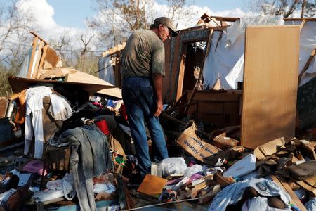 Bernard Sutton, 64, picks through the remains of his home destroyed by Hurricane Michael in Fountain, Florida, U.S., October 15, 2018. REUTERS/Terray Sylvester