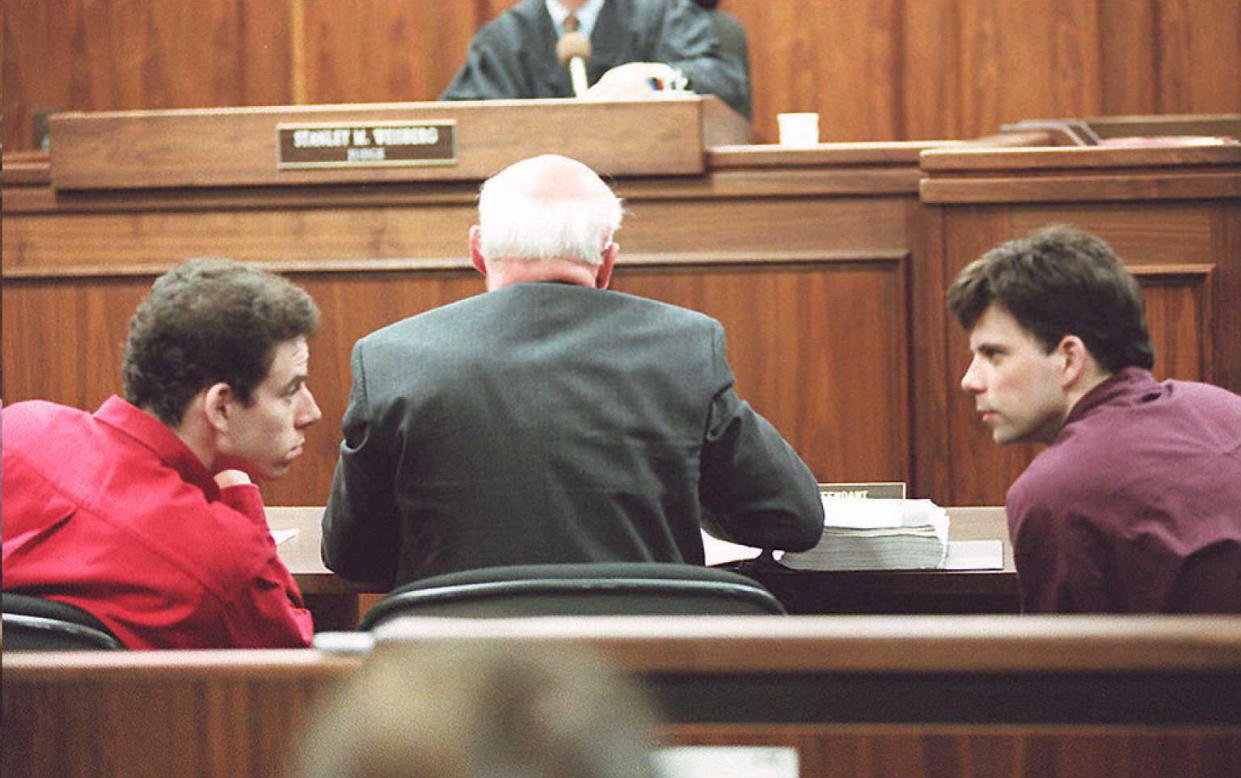 LOS ANGELES, UNITED STATES:  Erik (L) and Lyle (R) Menendez converse in the courtroom during a hearing in Los Angeles, in this 02 February 1995 file picture. They are accused of murdering their parents in 1989. (Photo credit should read KIM KULISH/AFP via Getty Images)