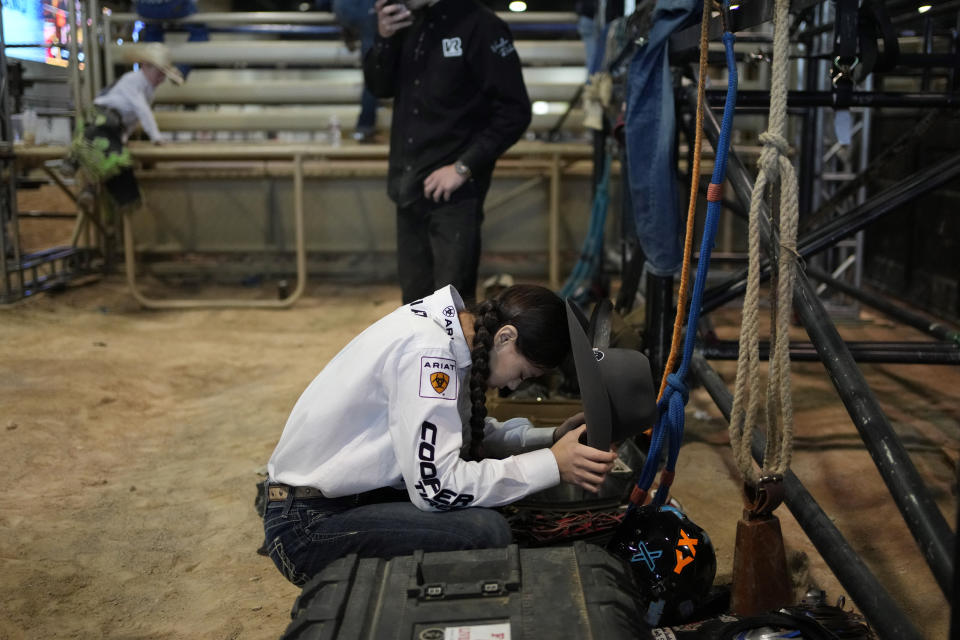 Najiah Knight prays before competing in the bull riding competition during the Junior World Finals rodeo, Thursday, Dec. 7, 2023, in Las Vegas. Najiah, a high school junior from small-town Oregon, is on a yearslong quest to become the first woman to compete at the top level of the Professional Bull Riders tour. (AP Photo/John Locher)