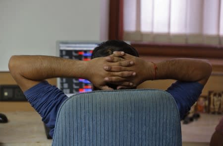 A broker reacts while trading at his computer terminal at a stock brokerage firm in Mumbai