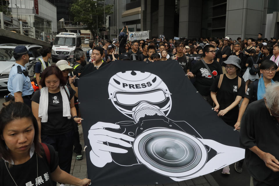 Hundreds of journalists hold banner during a silent march outside the police headquarters in Hong Kong, Sunday, July 14, 2019, demanding police to stop assaulting journalists and obstructing reporting. (AP Photo/Kin Cheung)
