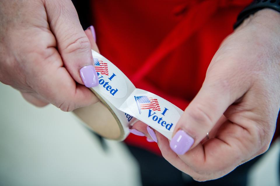 An election official holds a roll of "I Voted" stickers at the West Asheville Recreation Center, March 5, 2023.