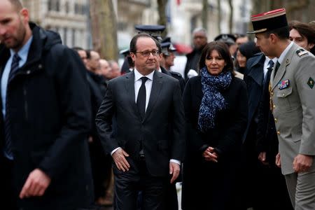 French President Francois Hollande (C) and Paris Mayor Anne Hidalgo attend a ceremony to unveil a commemorative plaque at the site where policeman Ahmed Merabet was killed during the last year's January attack in Paris, France, January 5, 2016. REUTERS/Benoit Tessier