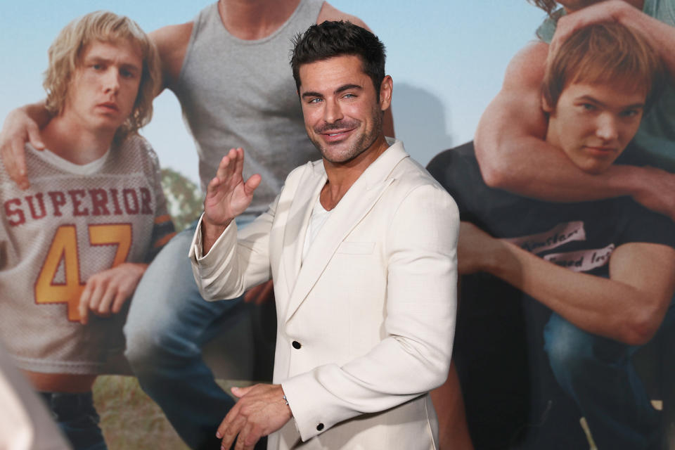 Close-up of Zac smiling and waving at a media event