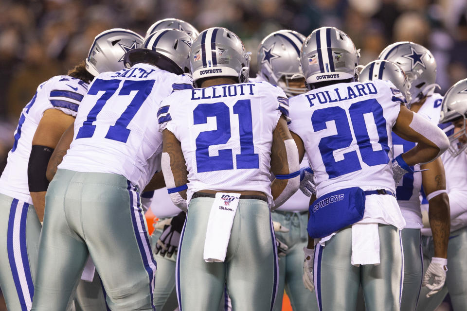 Tyron Smith #77, Ezekiel Elliott #21, and Tony Pollard #20 of the Dallas Cowboys 