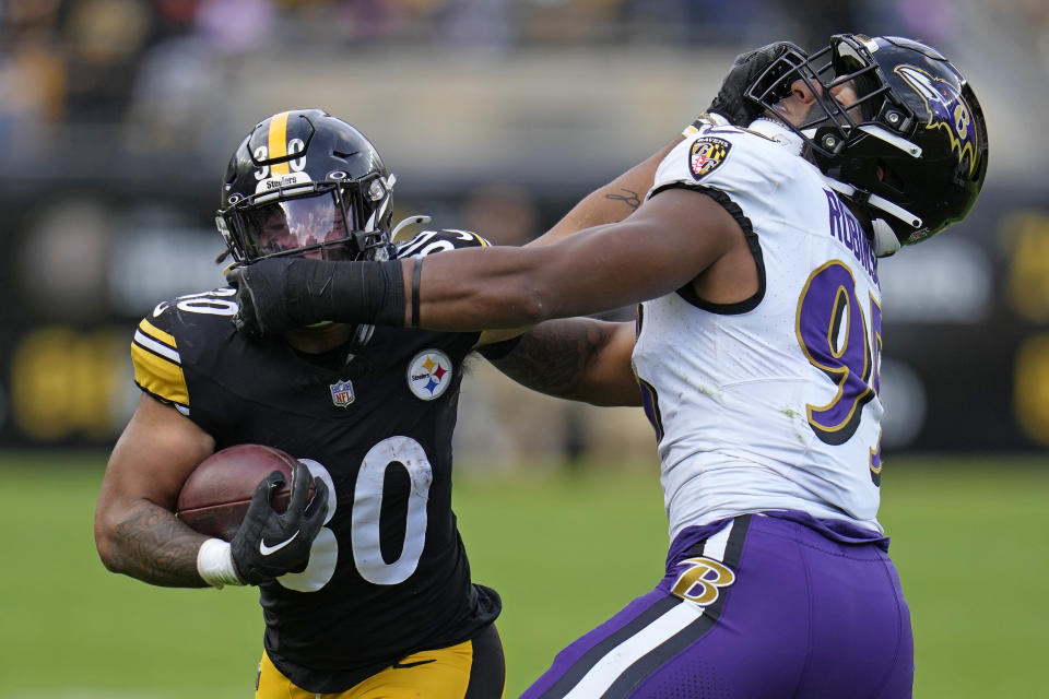 Pittsburgh Steelers running back Jaylen Warren (30) stiff-arms Baltimore Ravens linebacker Tavius Robinson (95) during second half an NFL football game in Pittsburgh, Sunday, Oct. 8, 2023. (AP Photo/Gene J. Puskar)