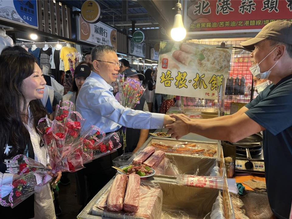 民眾黨主席柯文哲、黨籍立委林憶君到重慶市場拜會，致贈康乃馨。（王志偉攝）
