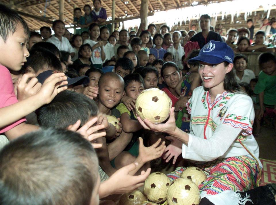 THAM HIN, THAILAND - MAY 20:  Hollywood actress Angelina Jolie distributes balls to the children at the Tham Hin refugee camp on the Thai-Burma border 19 May, 2002.  Jolie visited the camp, which is 180 kilometres west of Bangkok, as part of her role as goodwill ambassador for the United Nations High Commissioner for Refugees.  (Photo credit should read SHKREE SUKPLANG/AFP/Getty Images)