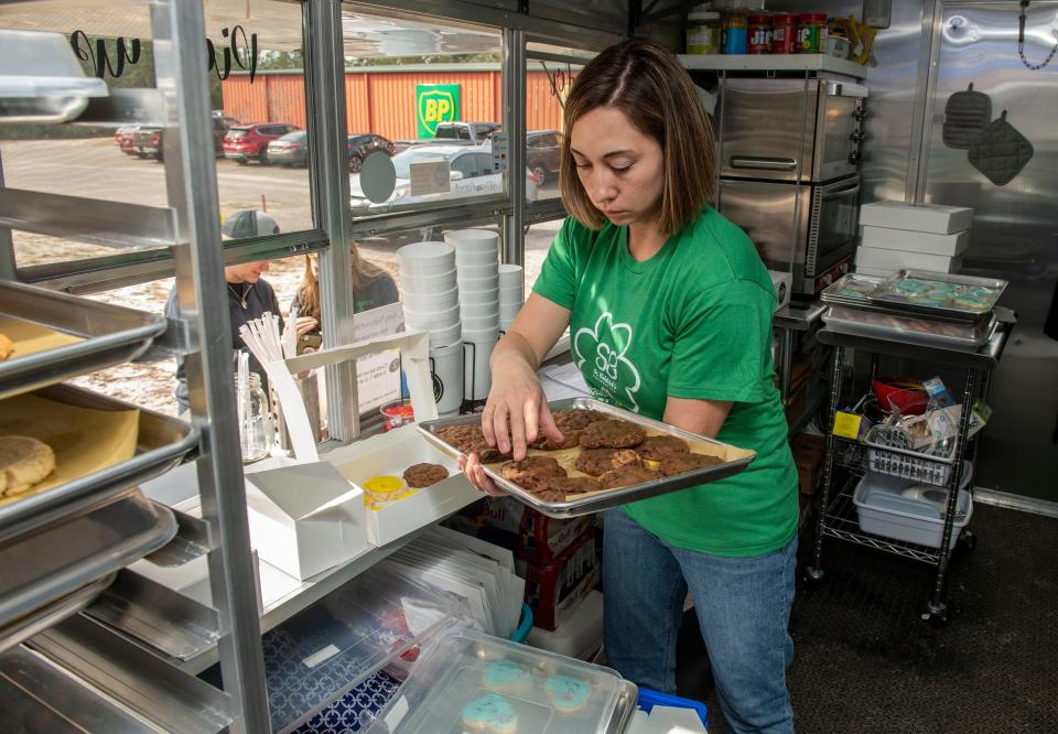 Co-owner  Alison Kadz packs up a cookie order at SodaShine gourmet soda and treats at The Market in Gulf Breeze Saturday, February 12, 2022.