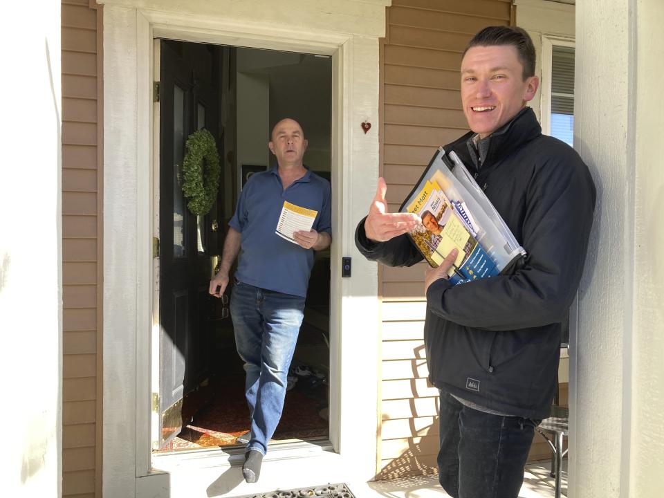 Matt Norris, a Democratic candidate for the Minnesota House, discusses issues with voter Howard Bureau in Blaine, Minn., on Wednesday, Oct. 26, 2022. (AP Photo/Steve Karnowski)