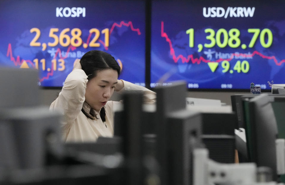 A currency trader watches monitors near the screens showing the Korea Composite Stock Price Index (KOSPI), top left, and the foreign exchange rate between U.S. dollar and South Korean won at the foreign exchange dealing room of the KEB Hana Bank headquarters in Seoul, South Korea, Tuesday, May 23, 2023. Asian stock markets were mixed Tuesday after more talks in Washington on government debt ended with no deal to avoid a potentially jarring default. (AP Photo/Ahn Young-joon)