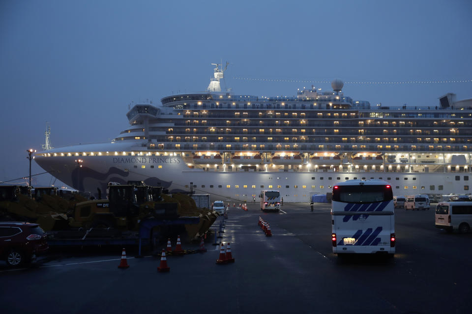 Buses arrive at a port as the Japan Self-Defense Forces prepare to move American passengers from the quarantined Diamond Princess cruise ship Sunday, Feb. 16, 2020, at Yokohama Port, near Tokyo. The U.S. says Americans aboard a quarantined ship will be flown back home on a chartered flight Sunday, but that they will face another two-week quarantine. (AP Photo/Jae C. Hong)