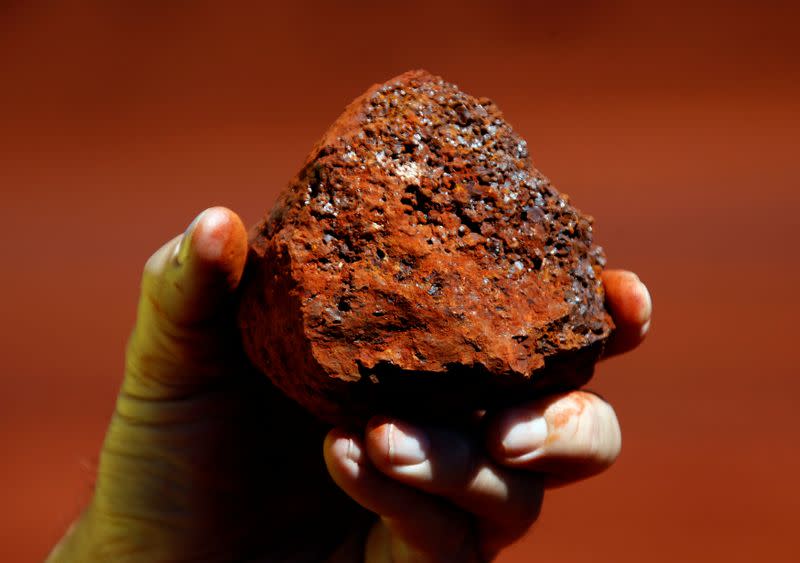 FILE PHOTO: A miner holds a lump of iron ore at a mine located in the Pilbara region of Western Australia