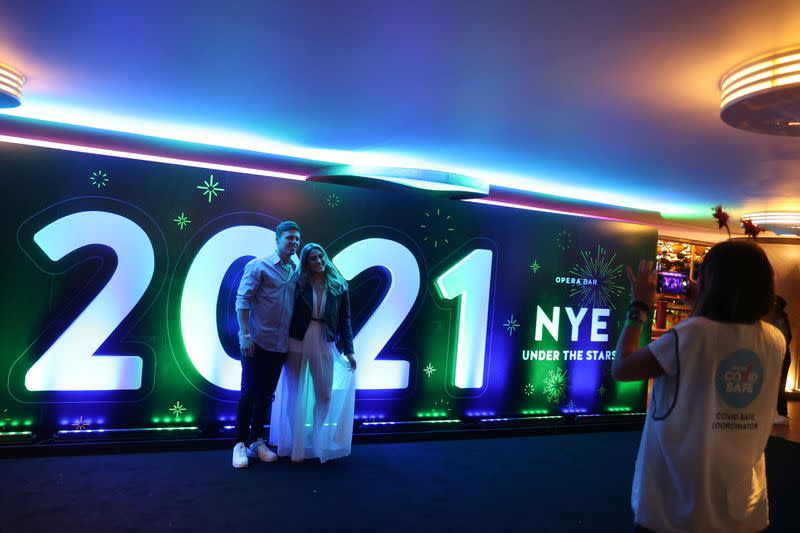 People begin celebrating New Year's Eve at the Sydney Harbour waterfront in Sydney