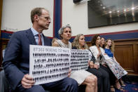 Michael Stumo and his wife Nadia Milleron, the parents of Samya Rose Stumo, hold up signs depicting those lost in Ethiopian Airlines Flight 302 and Lion Air Flight 610 during a House Committee on Transportation and Infrastructure hearing on the status of the Boeing 737 MAX on Capitol Hill in Washington, Wednesday, June 19, 2019. (AP Photo/Andrew Harnik)