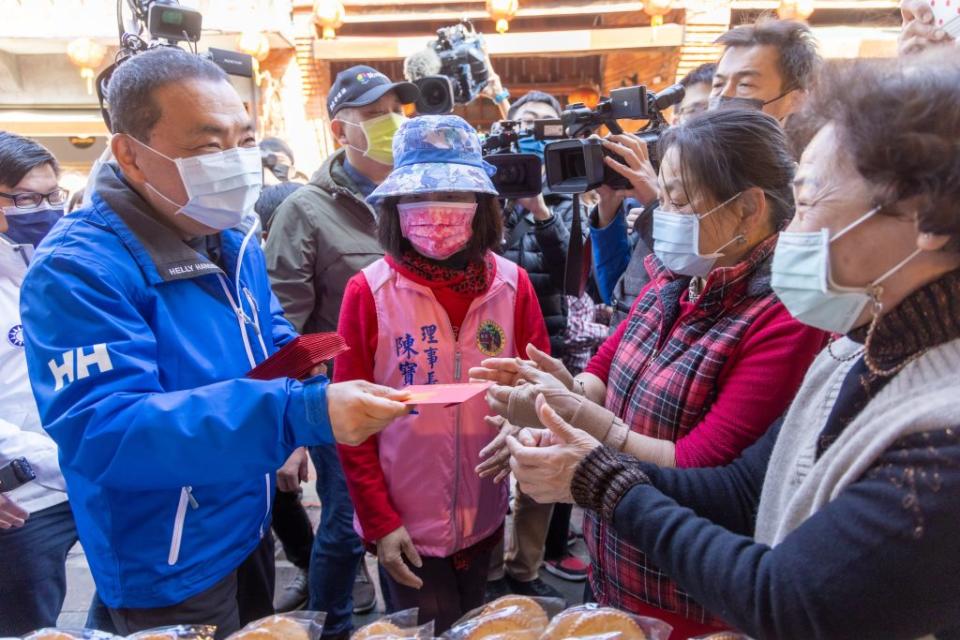 新北市長侯友宜二十九日前往深坑老街走春，發送福袋給老街店家和民眾，並訪視疫後商圈景氣回甦狀況。（記者蔡琇惠攝）