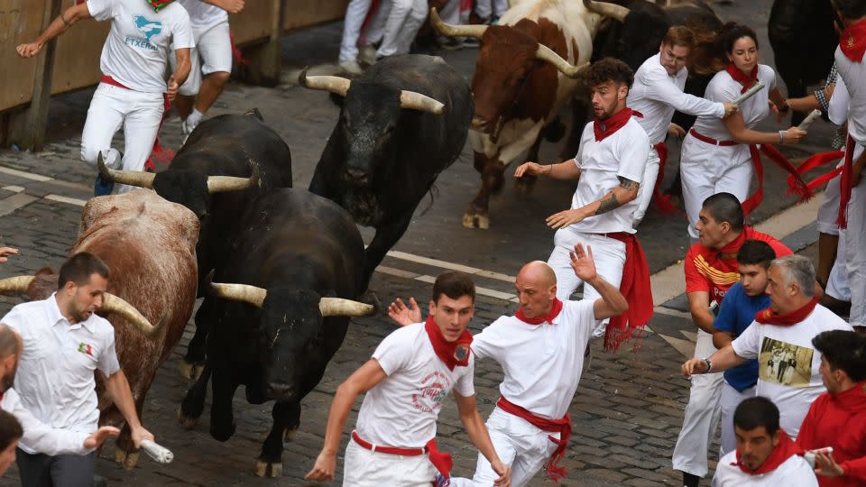 Participants run ahead of bulls during the "encierro" (bull-run) of the San Fermín festival in Pamplona, northern Spain, on July 14, 2023. - Miguel Riopa/AFP/Getty Images