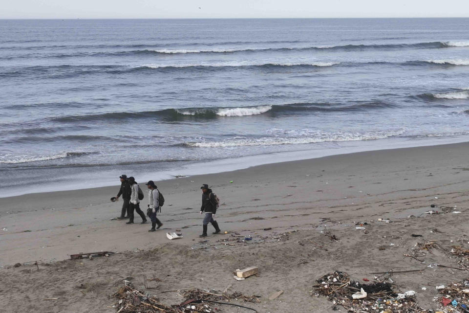 Pescadores caminan por la playa de Cavero en Ventanilla, Perú, el lunes 15 de enero de 2024. Dos días después de lo que las autoridades consideran el peor derrame de petróleo en la historia de Perú, las playas siguen cerradas para los turistas y y el sustento de los pescadores está destruido. (AP Foto/Guadalupe Pardo)