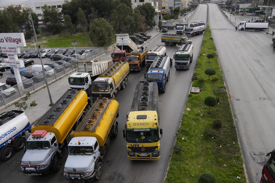 Tanker trucks block a main highway during a general strike by public transport and labor unions to protest the country's deteriorating economic and financial conditions in Beirut, Lebanon, Thursday, Jan. 13, 2022. Protesters closed the country's major highways as well as roads inside cities and towns starting 5 a.m. making it difficult for people to move around. (AP Photo/Hussein Malla)