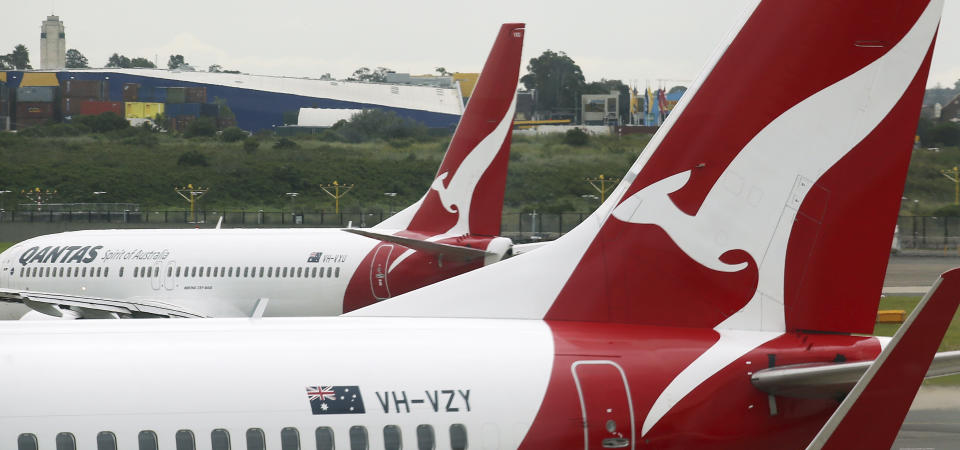 FILE - In this Feb. 26, 2015, file photo, a Qantas plane maneuvers behind another parked at a gate at Sydney Airport in Sydney. Qantas Airways chief executive Alan Joyce said on Thursday, Feb. 25, 2021, he doesn't expect his airline will resume international travel except for New Zealand until late October, after the Australian population is vaccinated for COVID-19. (AP Photo/Rick Rycroft, File)