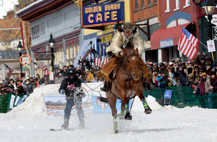 A skijoring team competes in Leadville, Colo., on Saturday, March 2, 2024. Skijoring draws its name from the Norwegian word skikjoring, meaning “ski driving.” It started as a practical mode of transportation in Scandinavia and became popular in the Alps around 1900. Today’s sport features horses at full gallop towing skiers by rope over jumps and around obstacles as they try to lance suspended hoops with a baton, typically a ski pole that’s cut in half. (AP Photo/Thomas Peipert)