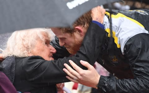 Prince Harry hugs Daphne Dunne, 97, during a walk around The Rocks in Sydney on June 7, 2017 - Credit: AFP