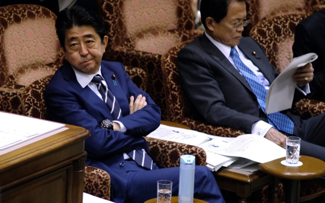 Japan's Prime Minister Shinzo Abe, left, attends an upper house budget committee session of parliament in Tokyo - AFP