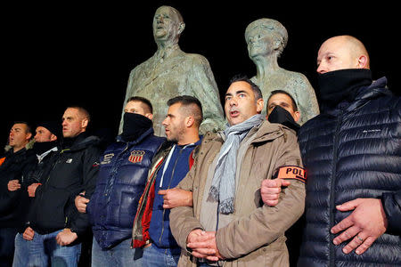 French plainclothes policemen gather singing the French national anthem in front of the statue of Charles de Gaulle and his wife, during an unauthorised protest against anti-police violence in Calais, France, late October 21, 2016. REUTERS/Pascal Rossignol