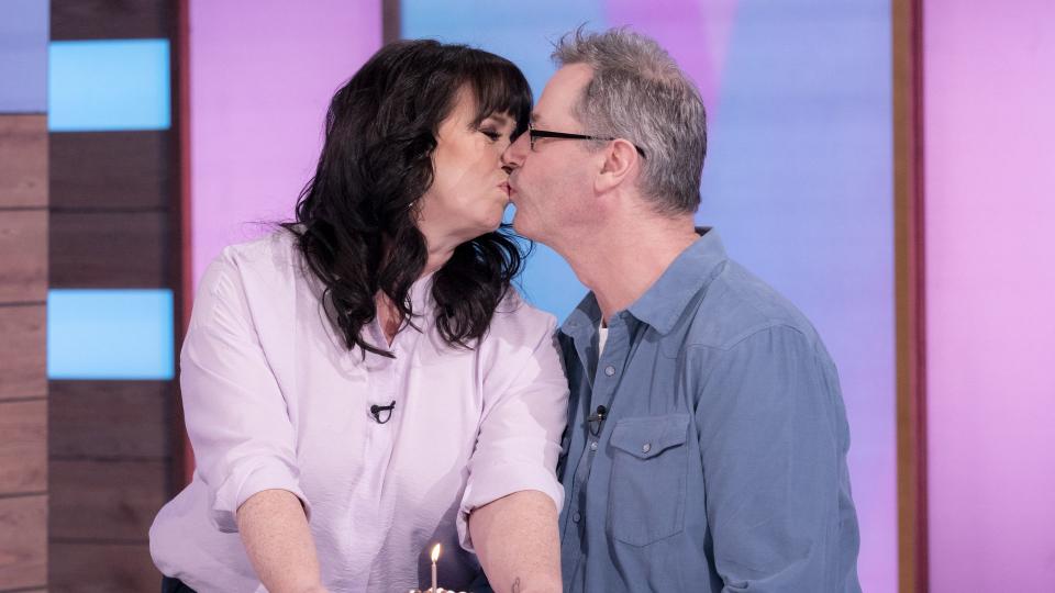 Coleen Nolan kissing Michael Jones while holding a cake