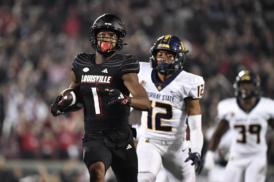 Louisville wide receiver Jamari Thrash (1) looks up at the scoreboard as he is chased by Murray State defensive back Justus Johnson (12) on the way to a touchdown during the first half of an NCAA college football game in Louisville, Ky., Thursday, Sept. 7, 2023. (AP Photo/Timothy D. Easley)