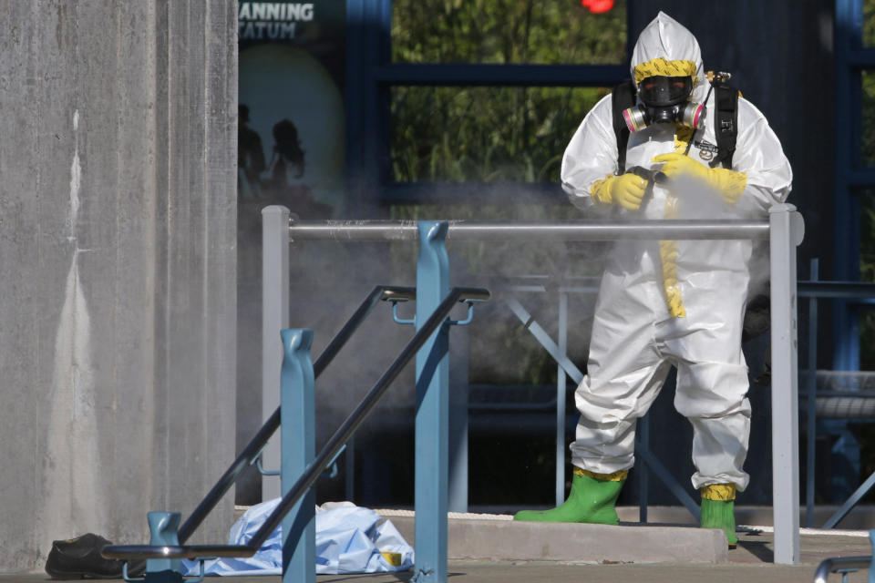 A first responder wears a full biohazard suit while spraying a disinfecting solution on the railing at the Dallas Area Rapid Transit (DART) White Rock Station after a woman with Ebola-like symptoms fell ill at the station October 18, 2014 in Dallas, Texas.
