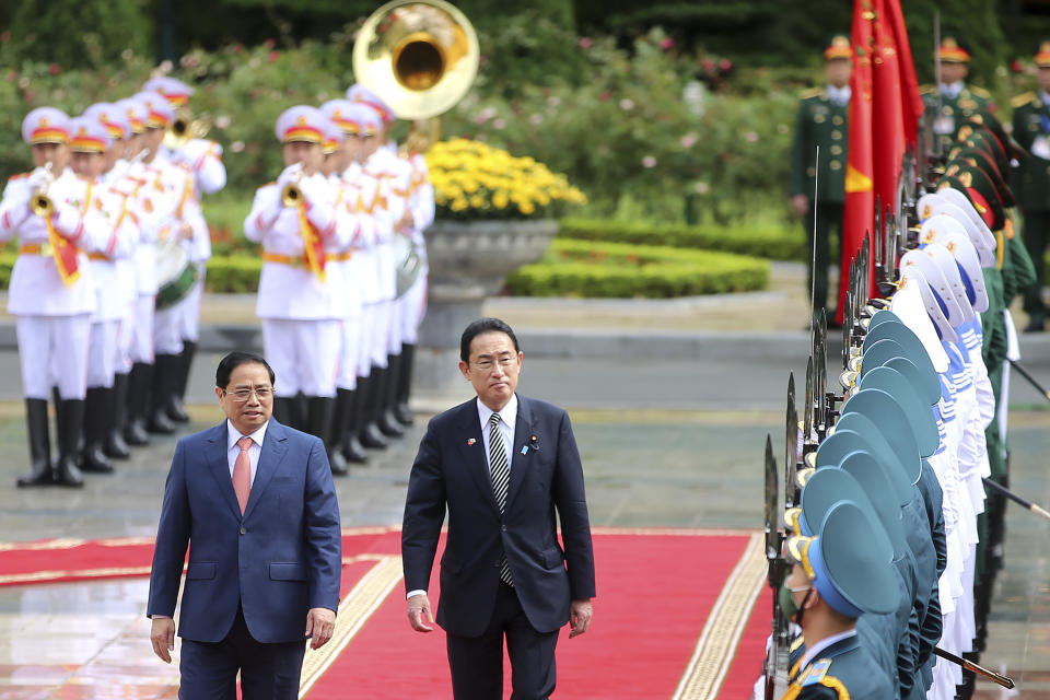 Japanese Prime Minister Fumio Kishida, right, and Vietnamese Prime Minister Pham Minh Chinh inspect honor guards in Hanoi, Vietnam on Sunday, May 1, 2022. (AP Photo/Hoang Minh)